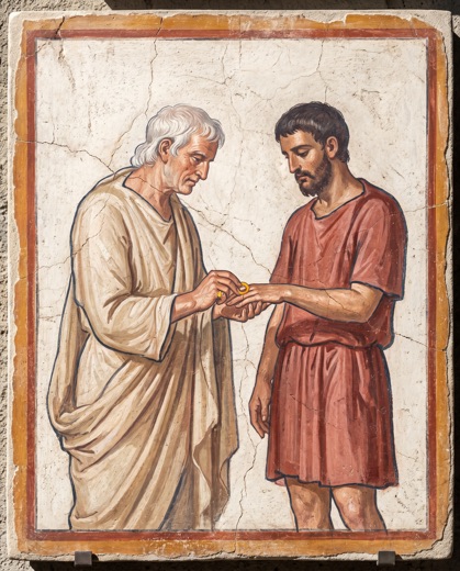 Un anciano coloca un anillo de oro en la mano de un hombre.
